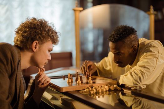 Two men focused on a chess game indoors, embodying strategy and concentration.
