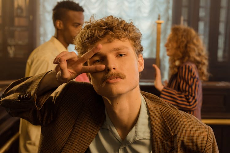 A Man In Plaid Suit Doing Peace Sign