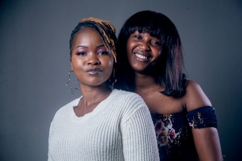 Free Two smiling women posing in a studio, showcasing friendship and joy. Stock Photo