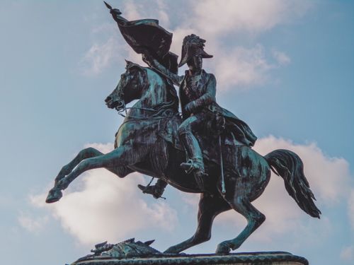 Free Dynamic bronze equestrian statue of historical figure in Vienna's cityscape. Stock Photo