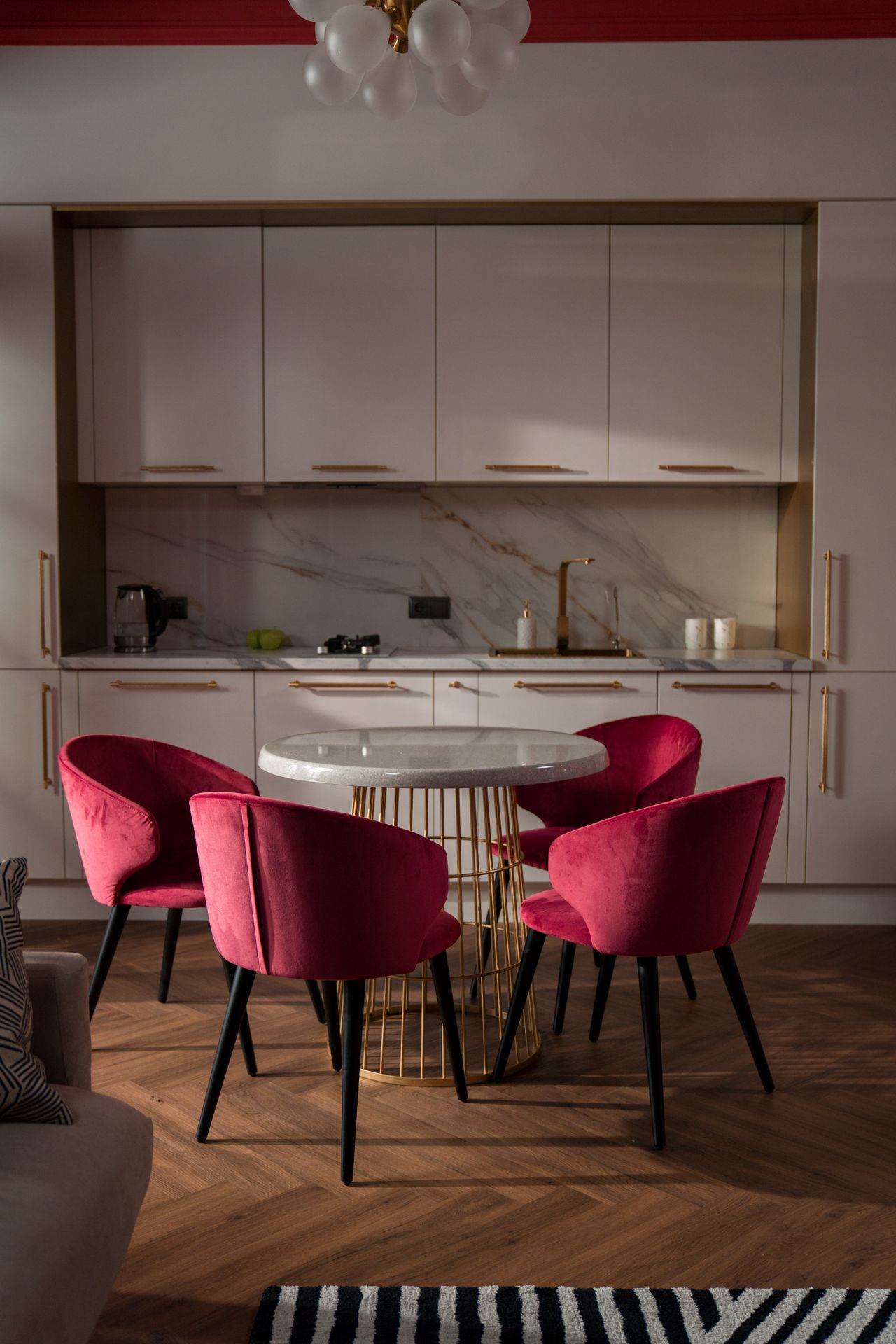 Round marble dining table with four red velvet chairs for comparison