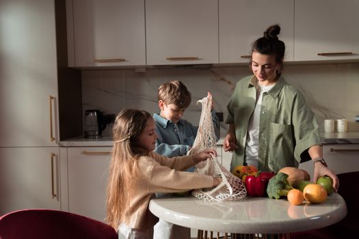 A happy family of three enjoying quality time unpacking vegetables in a modern kitchen.