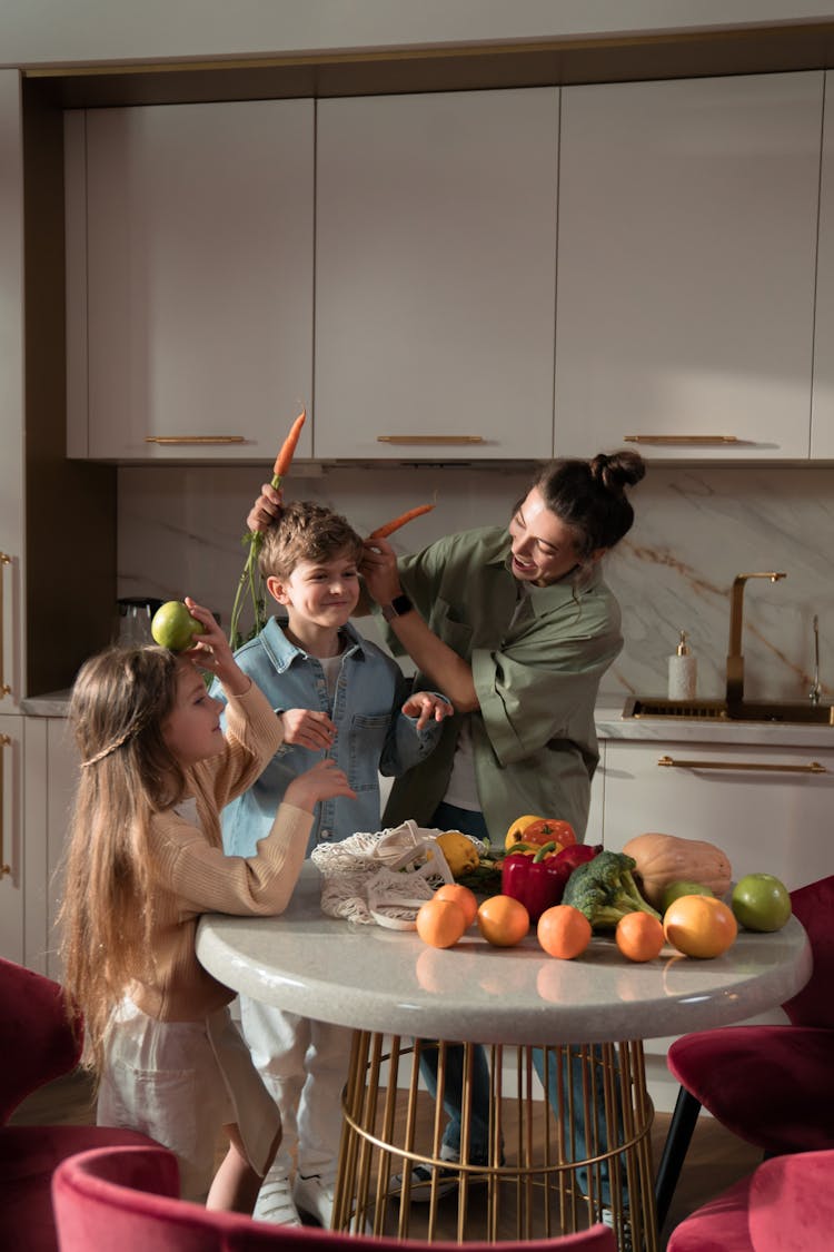 A Mother And Her Children Unpacking Goods In The Kitchen