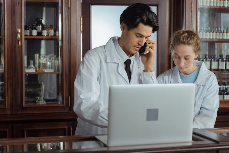 Man And Woman Working Together In A Pharmacy