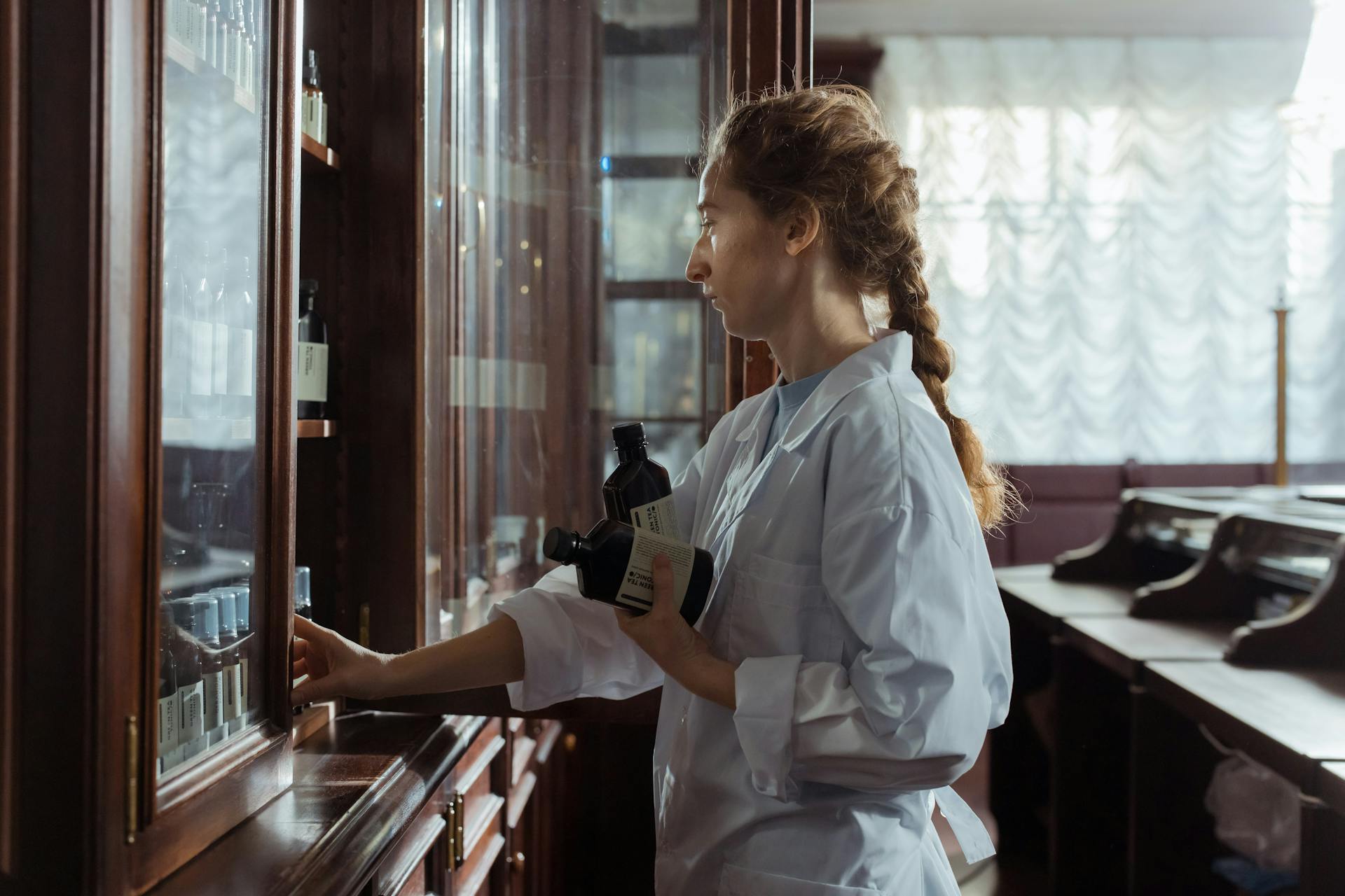 Female Pharmacist Getting Medicines on a Cabinet