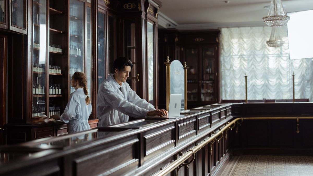 Pharmacists working in a vintage pharmacy setting with old-fashioned decor.
