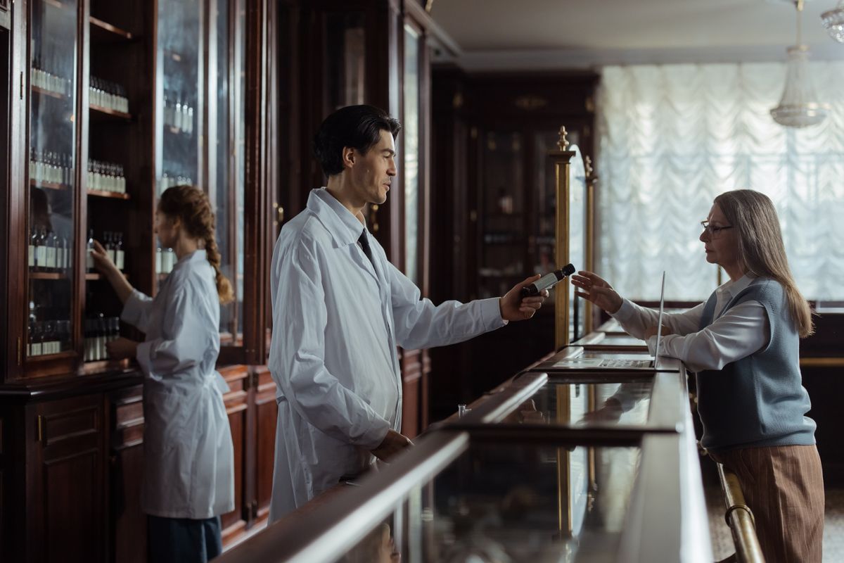 Farmacéutica entregando la medicación a un cliente en el mostrador