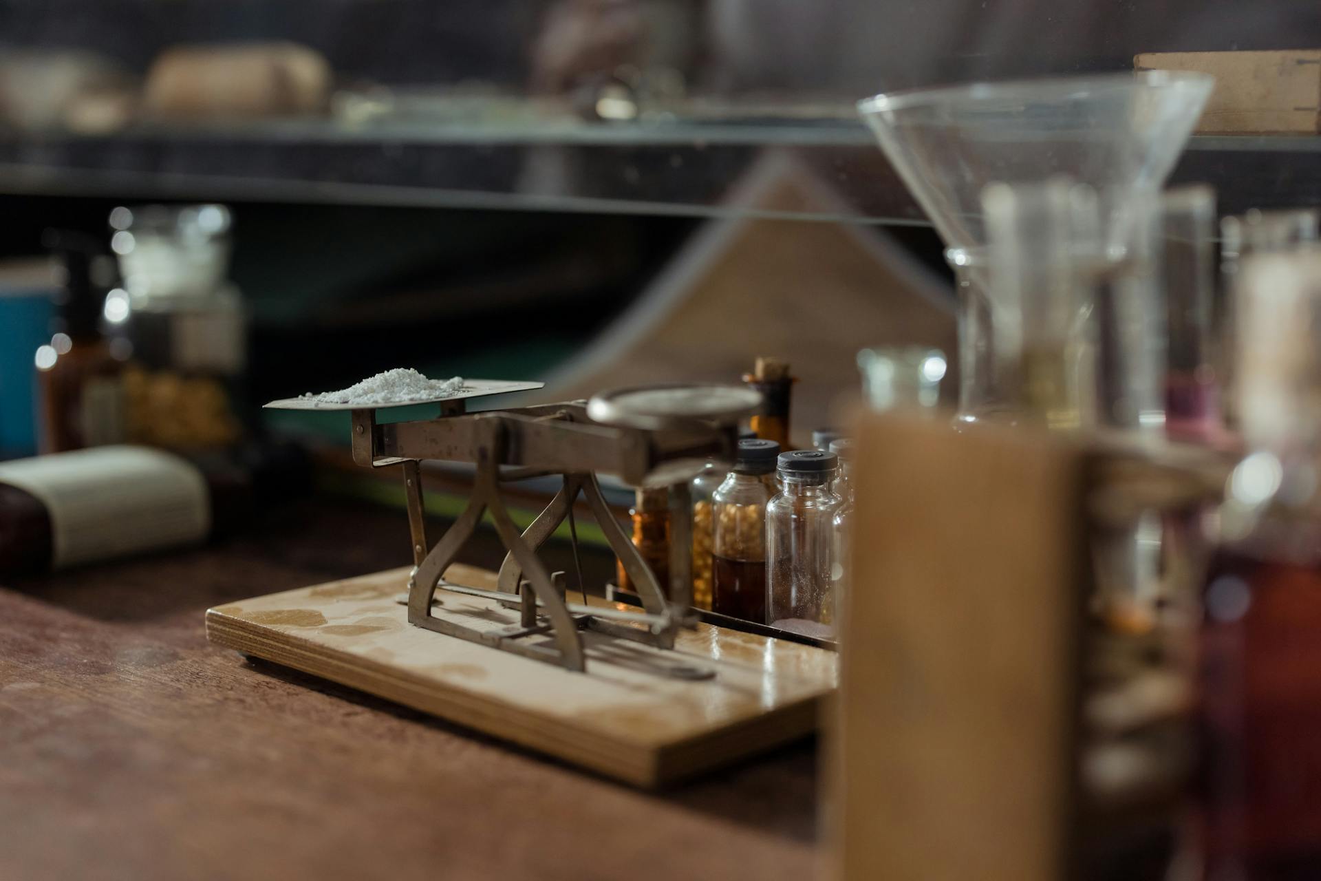 Close-up of Powdered Medication being Measured on a Vintage Scale Standing next to Pill Bottles