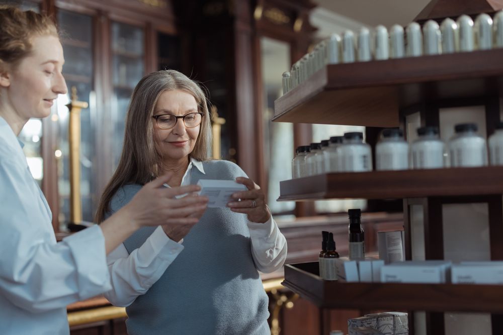 Pharmacist assisting an elderly client with a prescription