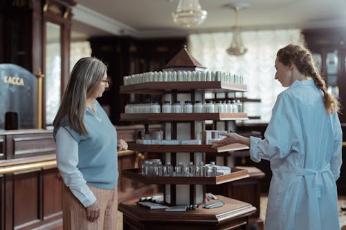 Customer Talking with Pharmacist by Medicaments Display