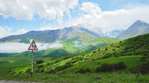 Free Breathtaking view of lush green mountains with a road sign in North Ossetia-Alania, Russia. Stock Photo