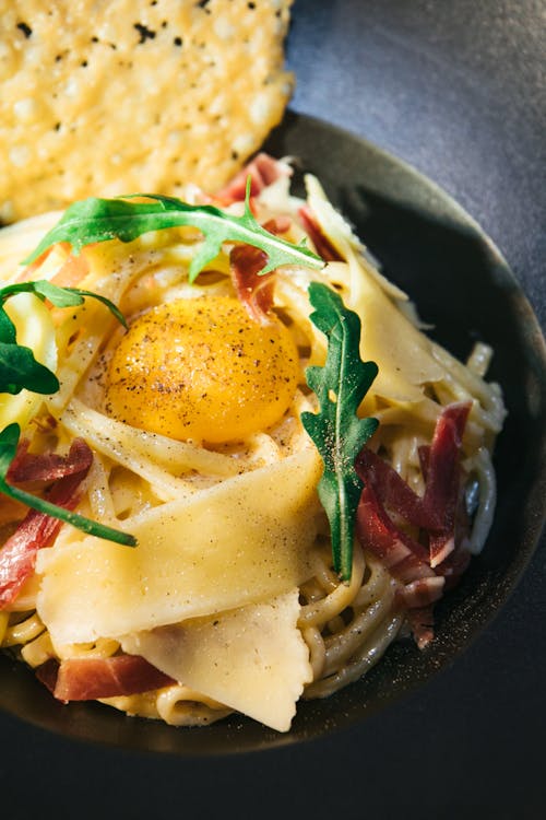 White Pasta Dish with Poached Egg on a Ceramic Plate