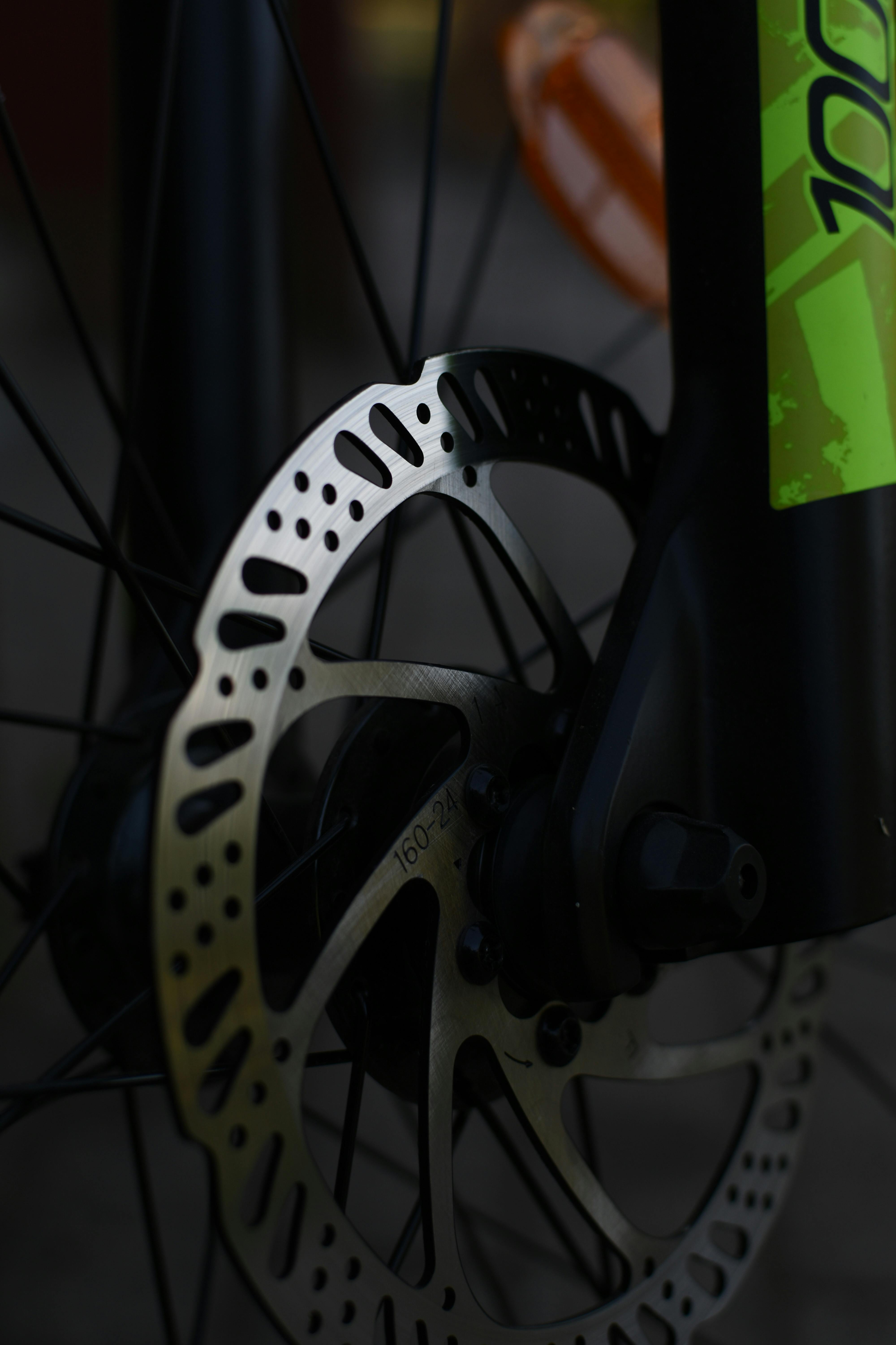 Detailed view of a bicycle wheel featuring modern disc brake system and vibrant color accents.