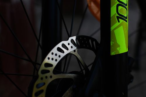 Free Detailed view of a modern bicycle disc brake with a vibrant green accent. Stock Photo