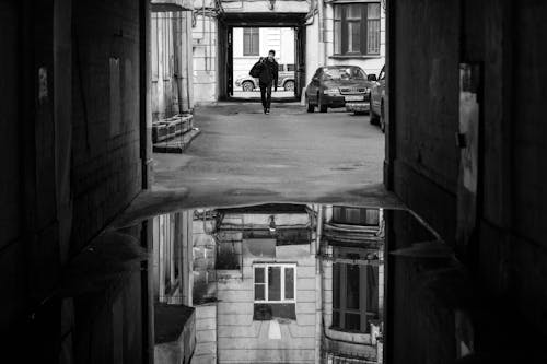 Free Monochrome Photo of a Man Walking in an Alley Stock Photo