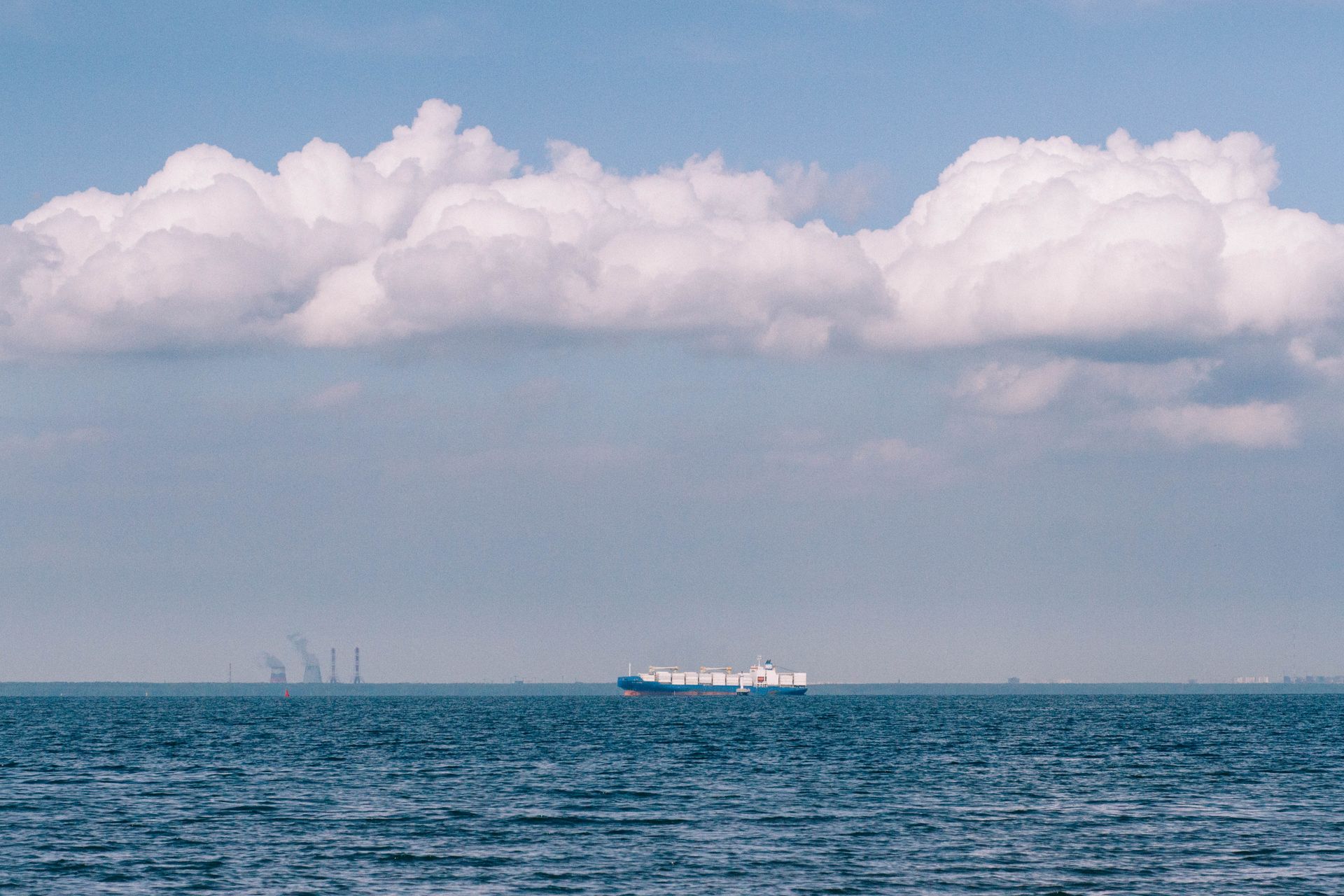 A container ship heading toward the horizon on open sea