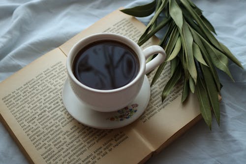 Close-Up Photo of Black Coffee on Top of Book