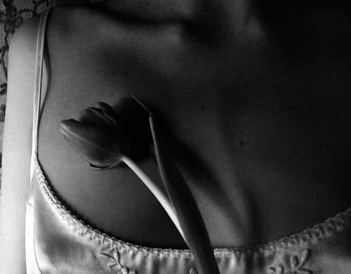 Grayscale Photo of a Tulip on a Woman's Chest