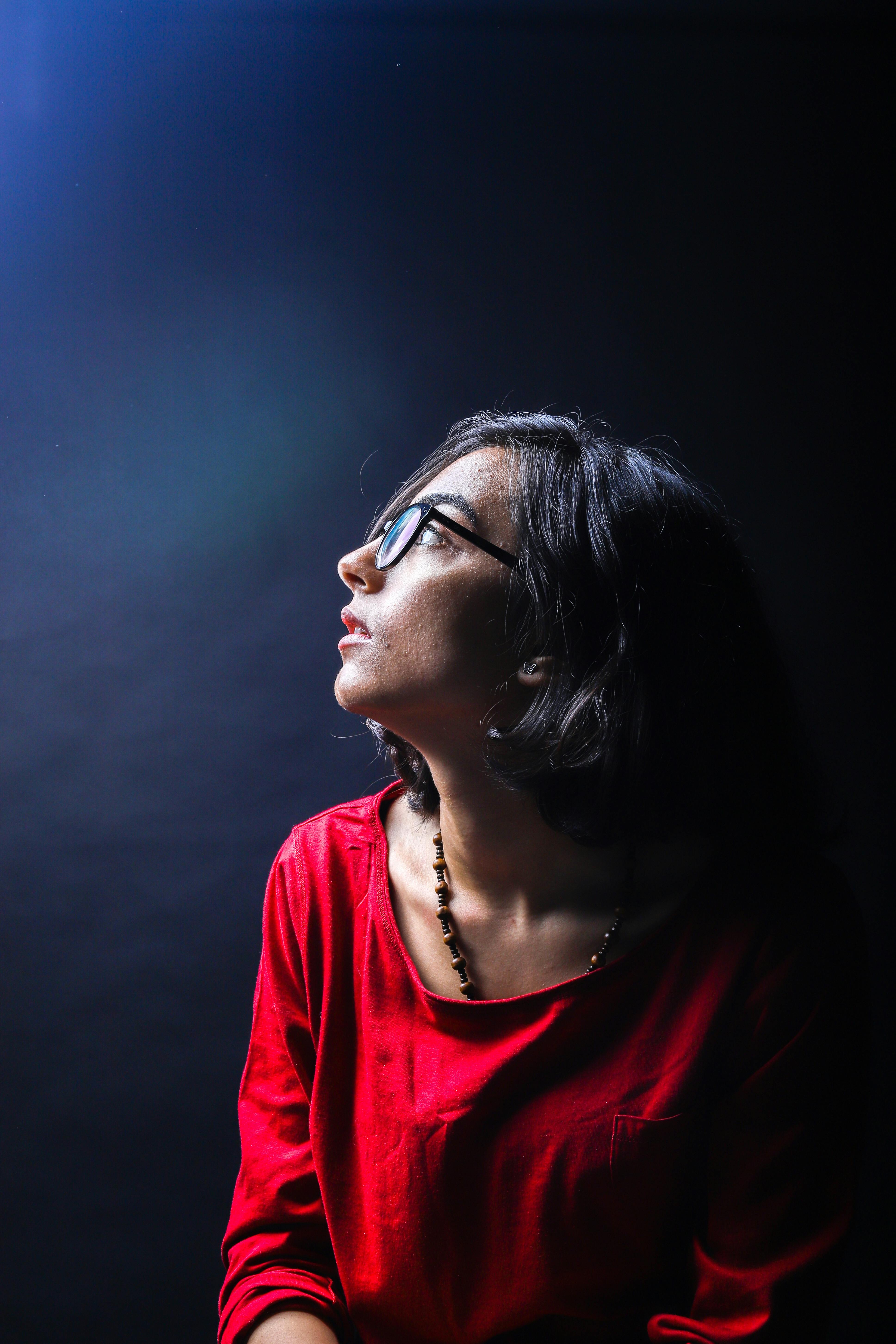 Side view portrait of an adult woman in a studio with dramatic lighting.