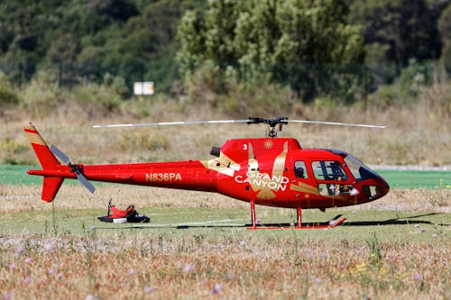 Free A Red Helicopter on Green Grass Field Stock Photo