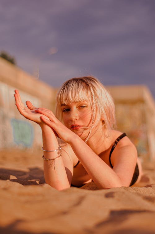 Blonde Woman Lying Down on Brown Sand
