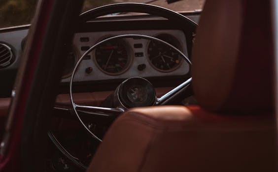 Close-up of a vintage car's interior showcasing a retro dashboard and classic steering wheel.