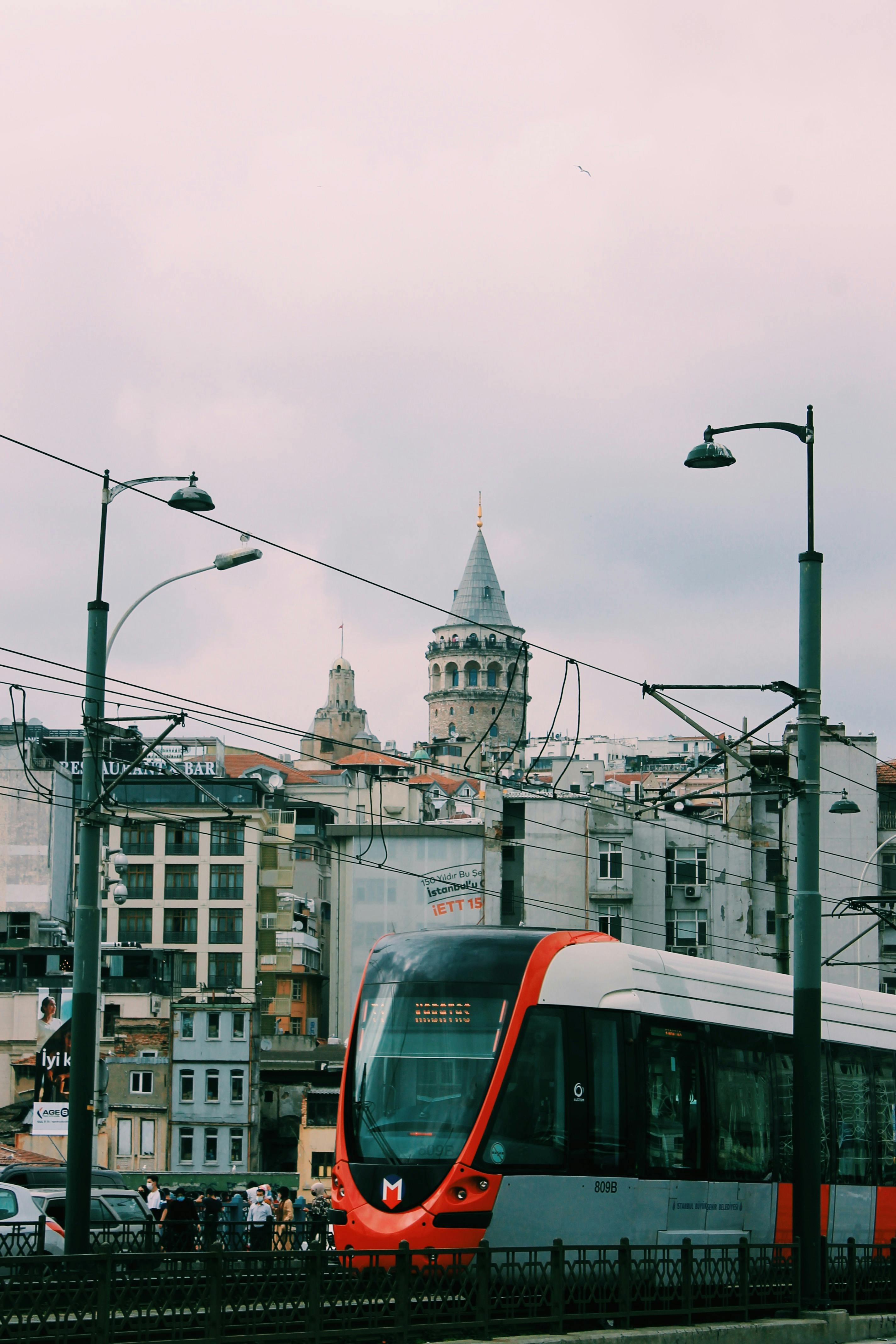 Free A modern tram travels through Istanbul with the iconic Galata Tower in the background. Stock Photo