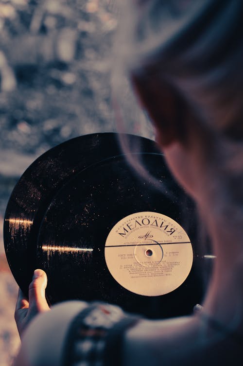 A Person Holding Vinyl Records