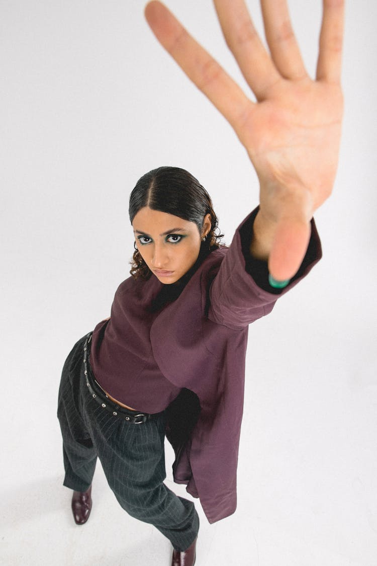 High-Angle Shot Of A Woman In A Purple Top Reaching With Her Hand