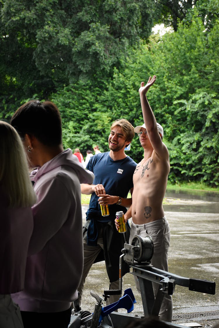 Man With Beer Cans Greeting Friends At A Park