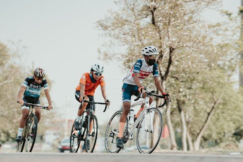 Photo of Men with Helmets Riding Their Bicycles