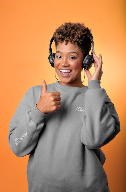 Woman Wearing Headphones Gesturing a Thumbs Up 
