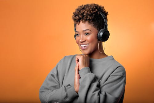 Woman in a Gray Long Sleeve Shirt Wearing Black Headphones