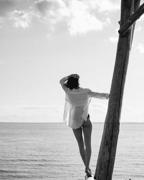 Free Grayscale Photo of a Woman Standing Near the Beach Stock Photo