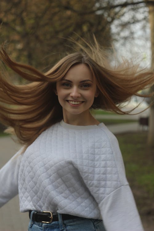 A Happy Woman Wearing White Long Sleeves Smiling at the Camera