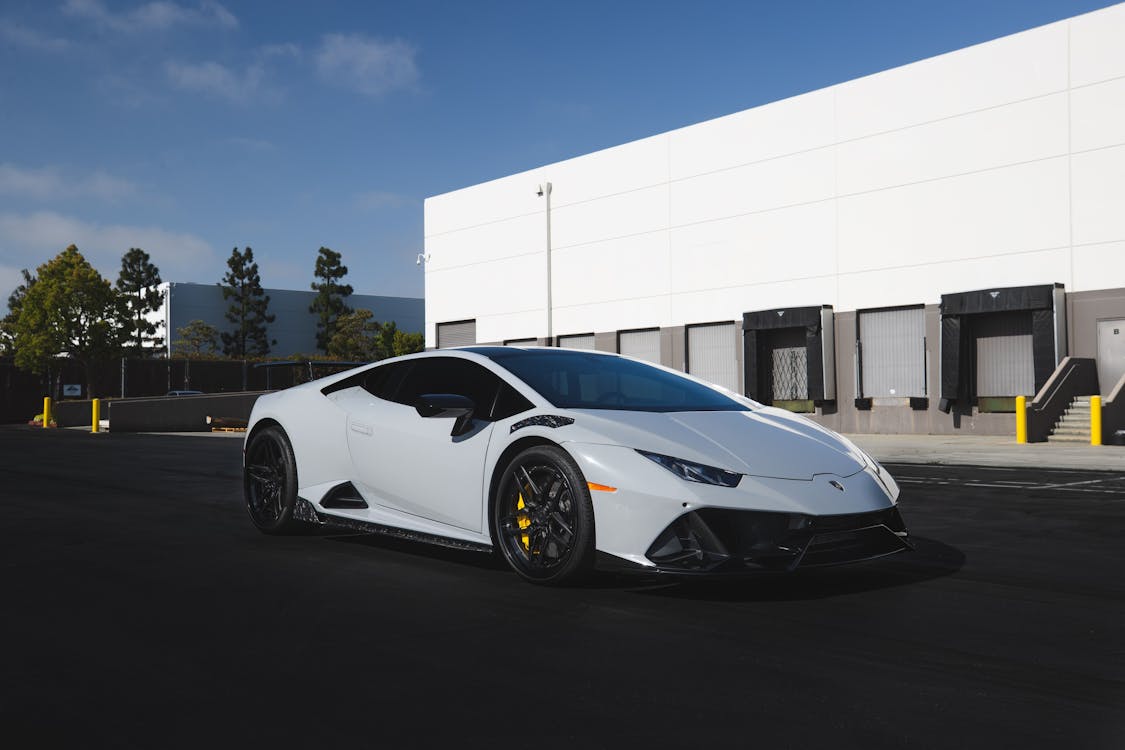 Free A White Lamborghini Sports Car Parked Outside Stock Photo
