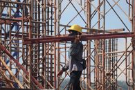 Man in Yellow Helmet Carrying Steels