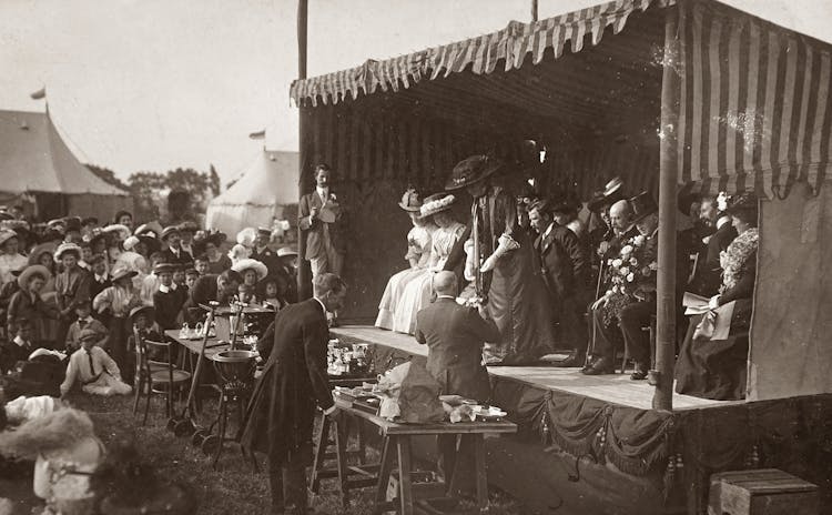 Grayscale Photo Of People On Stage With A Crowd Watching