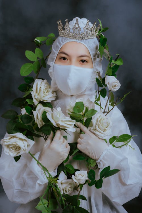 Woman Wearing White Protective Equipment with Crown on the Head Looking at the Camera
