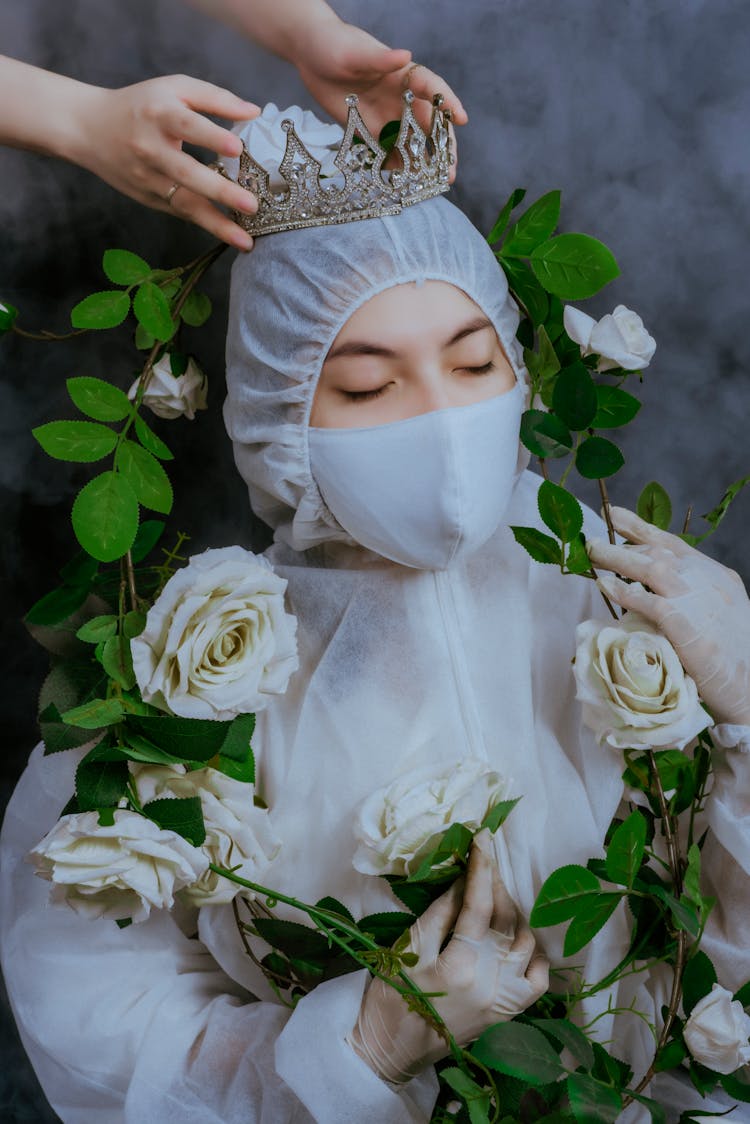 Studio Shoot Of A Woman Wearing Protective Clothing And Crown With White Roses Branch