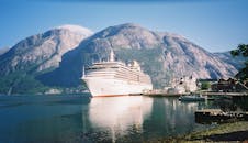 White Cruise Ship on Water Near Mountain