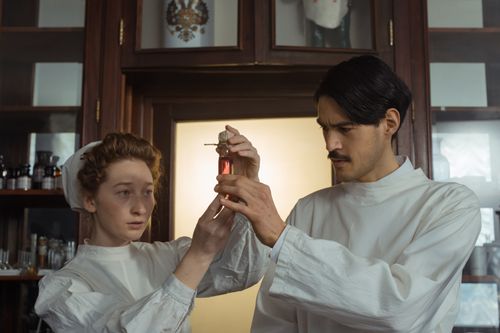 Free Two scientists in retro attire examine a test tube in a traditional laboratory setting. Stock Photo