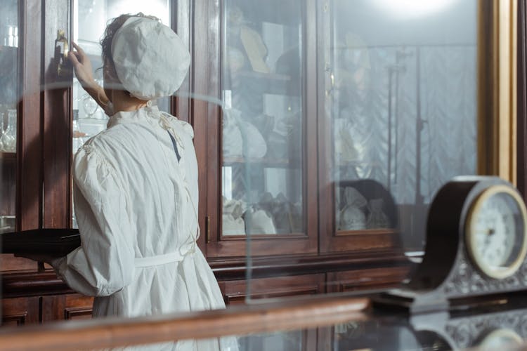 Back View Of A Woman Opening A Cabinet