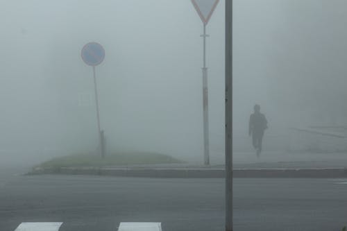 Free Photo of a Person Walking on a Street During a Foggy Day Stock Photo