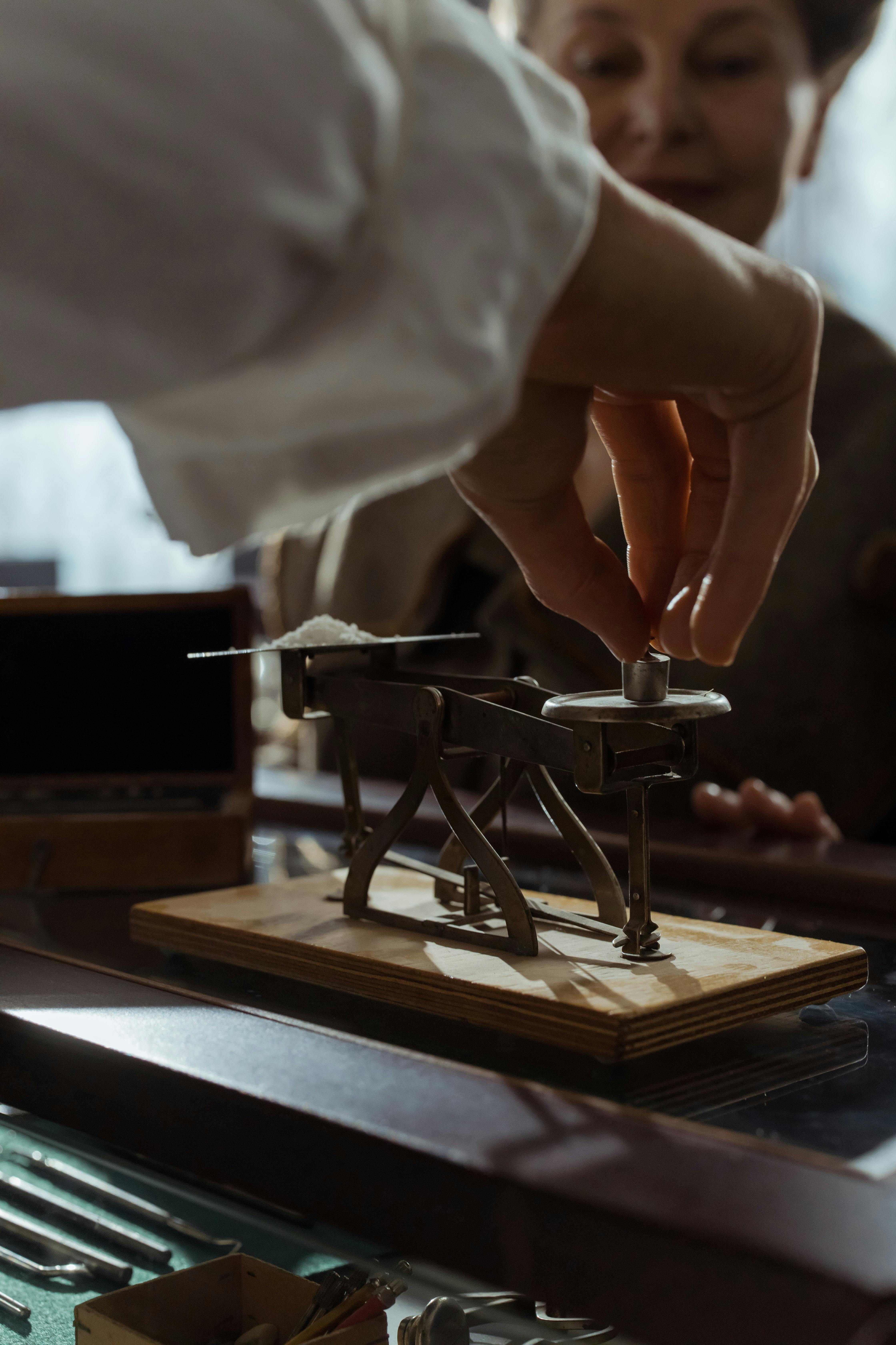 person using an antique weighing scale