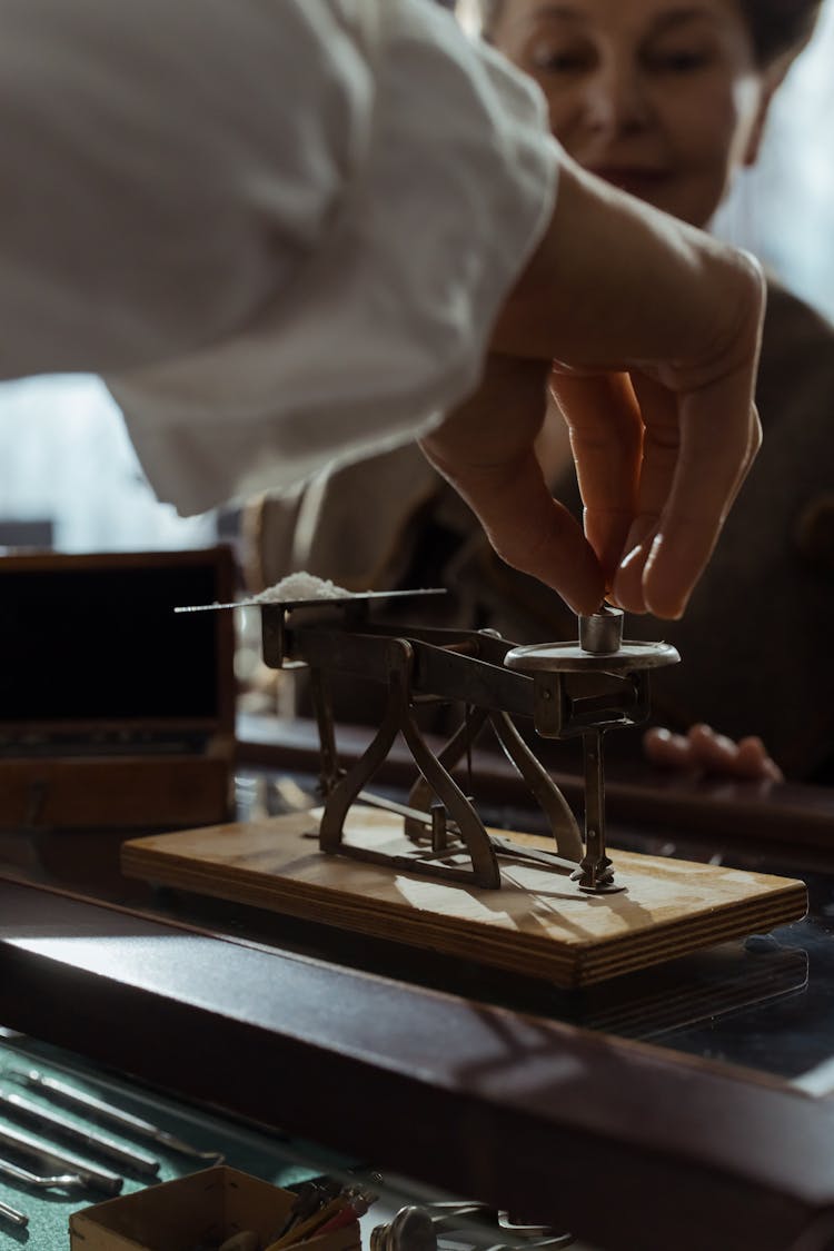 Person Using An Antique Weighing Scale