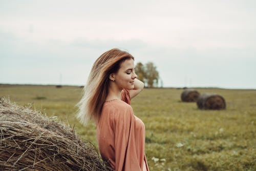 Woman Standing on Hay Field