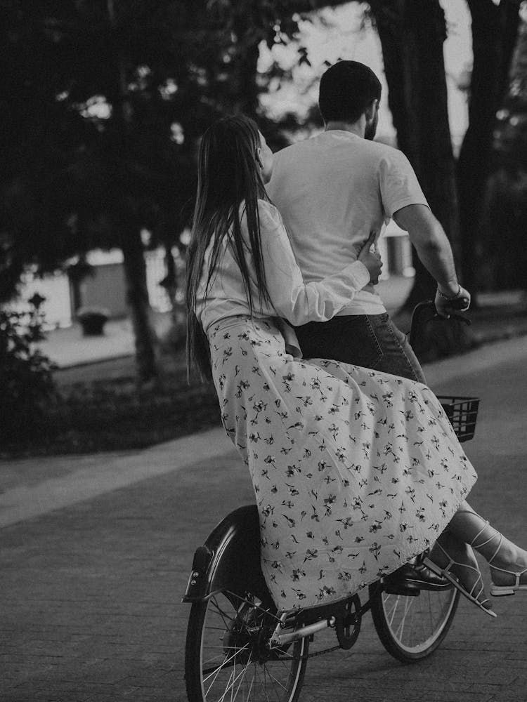 Grayscale Photo Of A Couple Biking