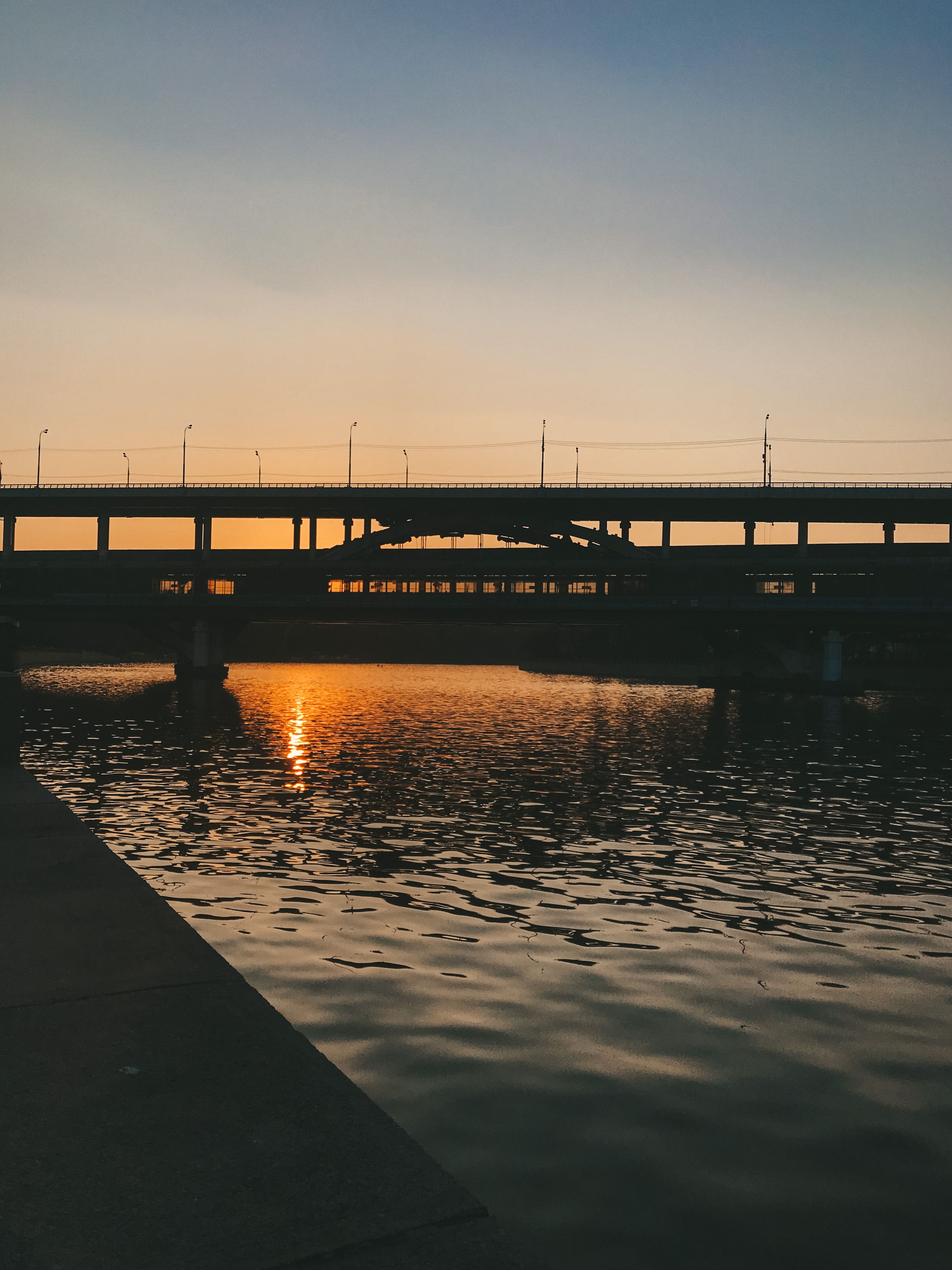 A Silhouette of a Body of Water During Golden Hour · Free Stock Photo