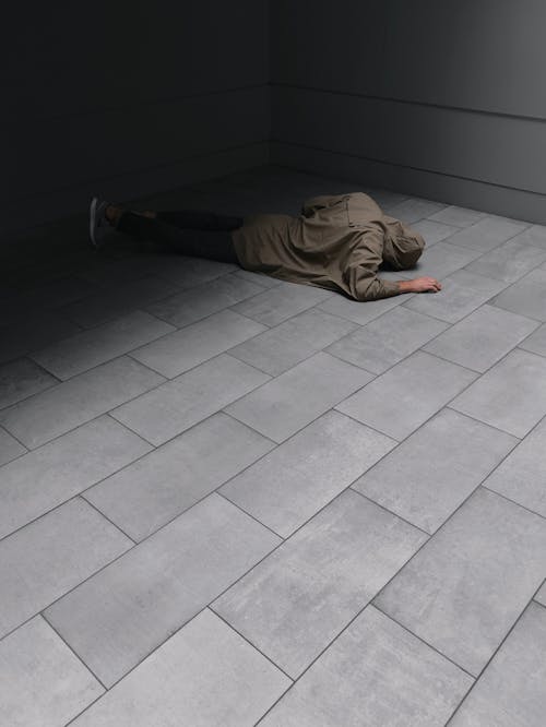 Free Person Wearing Grey Hoodie and Black Jeans Laying on Floor Stock Photo
